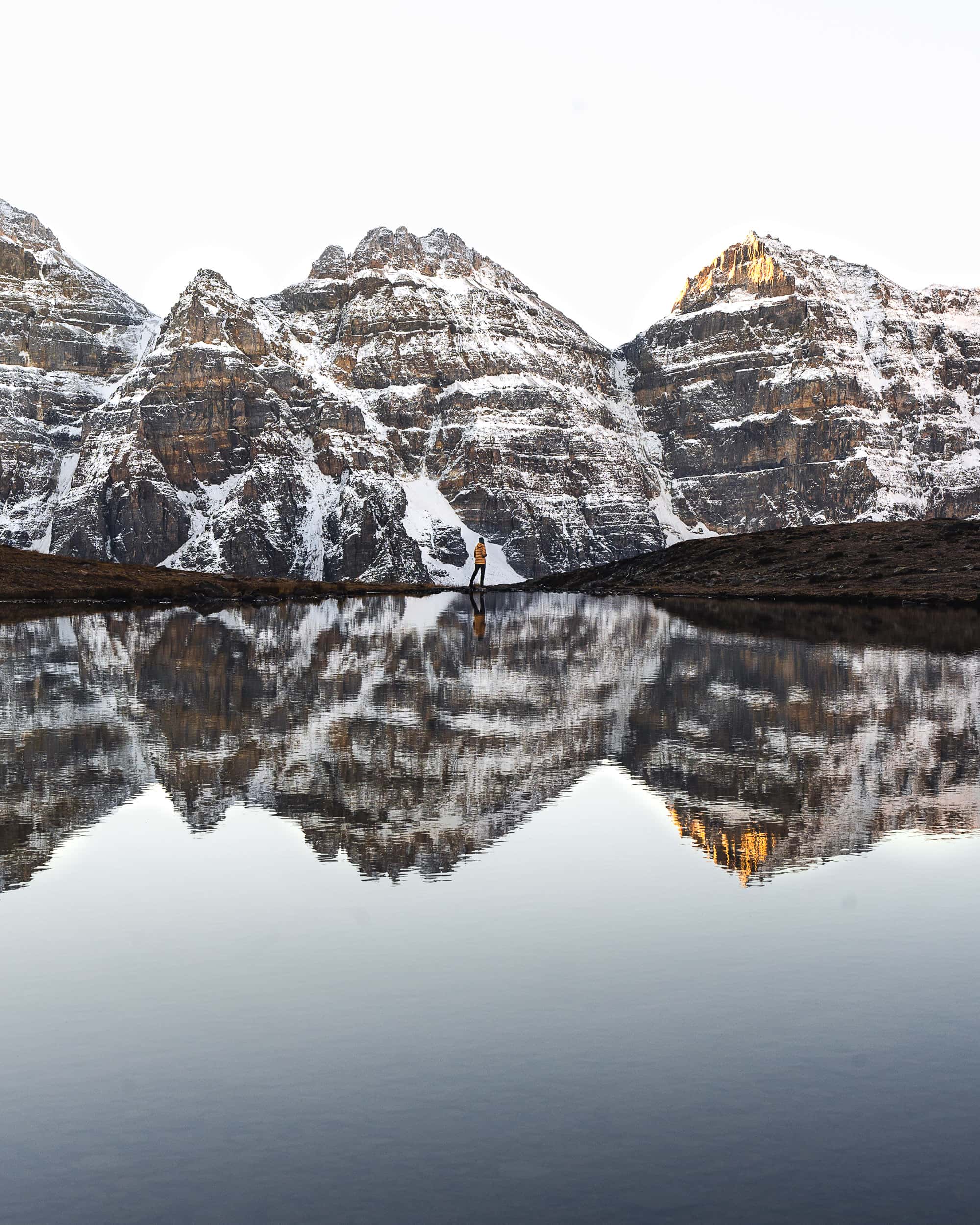 reflection of moraine lakes mountains on this alpine tarn on the larch valley hike
